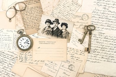 Old French handwritten notes and postcards with keys, a photograph, pocket watch and spectacles