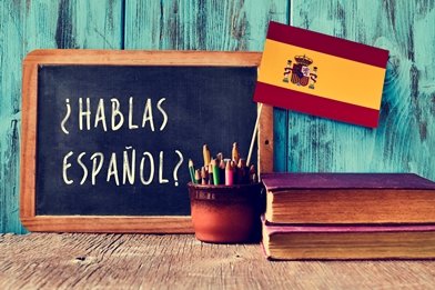 Hablas Espanol written on blackboard with Spanish flag